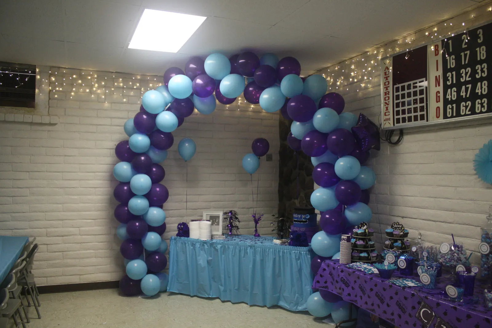 Rainbow organic balloon arch framing the dessert table at a Sweet n' Sassy Creations birthday party in East El Paso TX