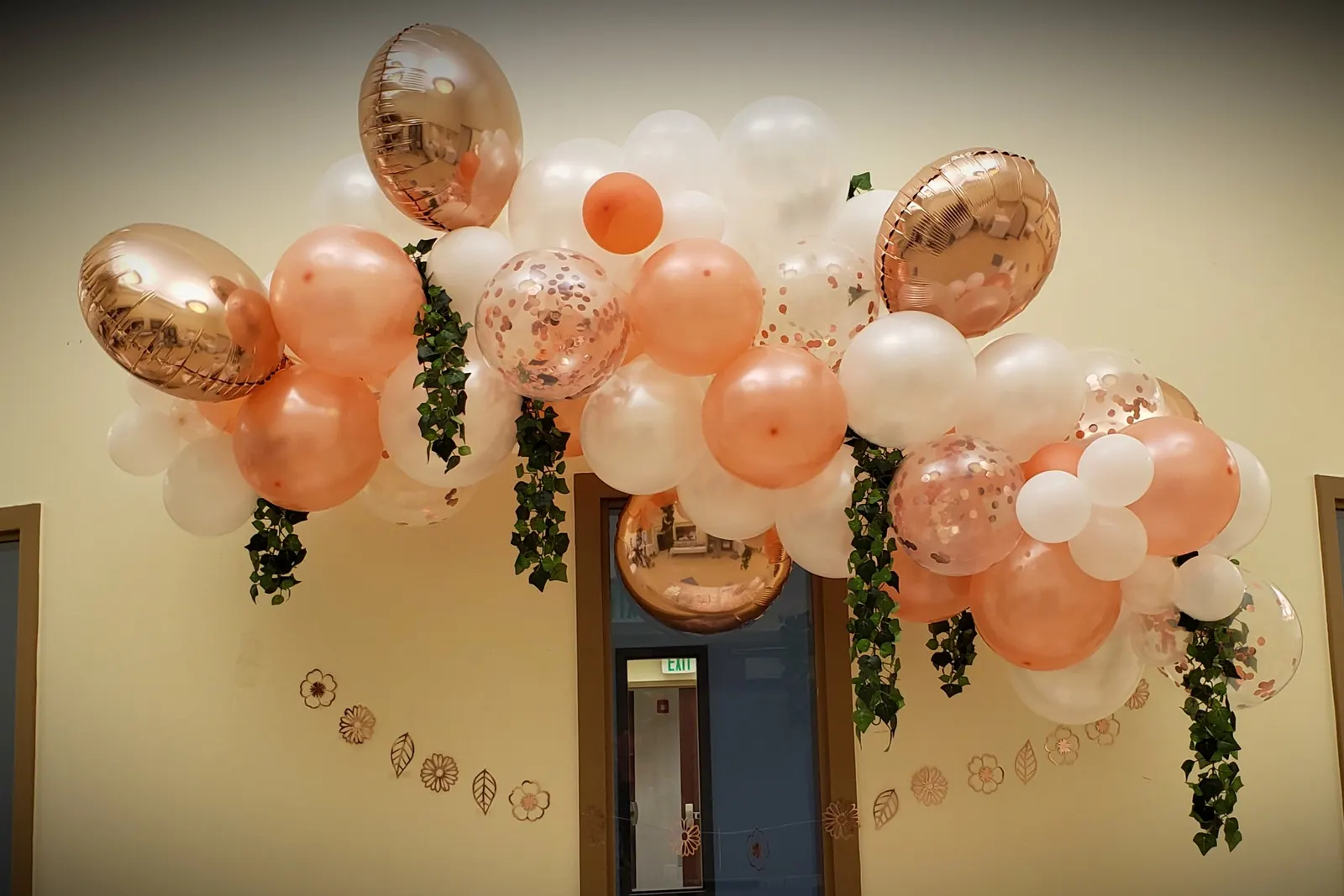 Stunning organic balloon garland arch in blush pink, hot pink, champagne gold, and white with eucalyptus and white roses at a quinceañera venue entrance in El Paso, TX — Sweet n' Sassy Creations