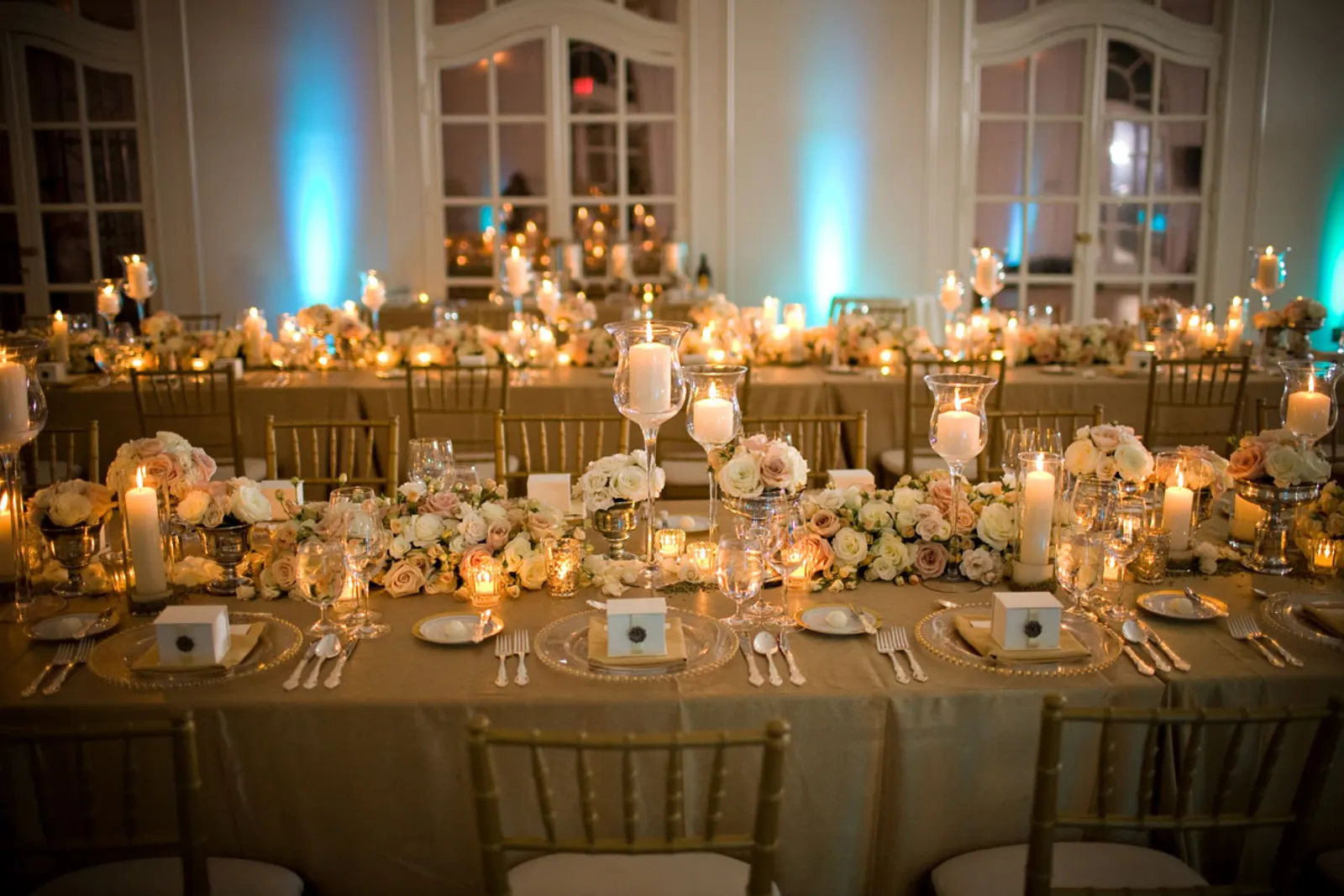 Close-up of elegant gold chiavari chairs with white cushions around a round table with white linen and pink rose centerpiece at an outdoor quinceañera in El Paso, TX — Sweet n' Sassy Creations
