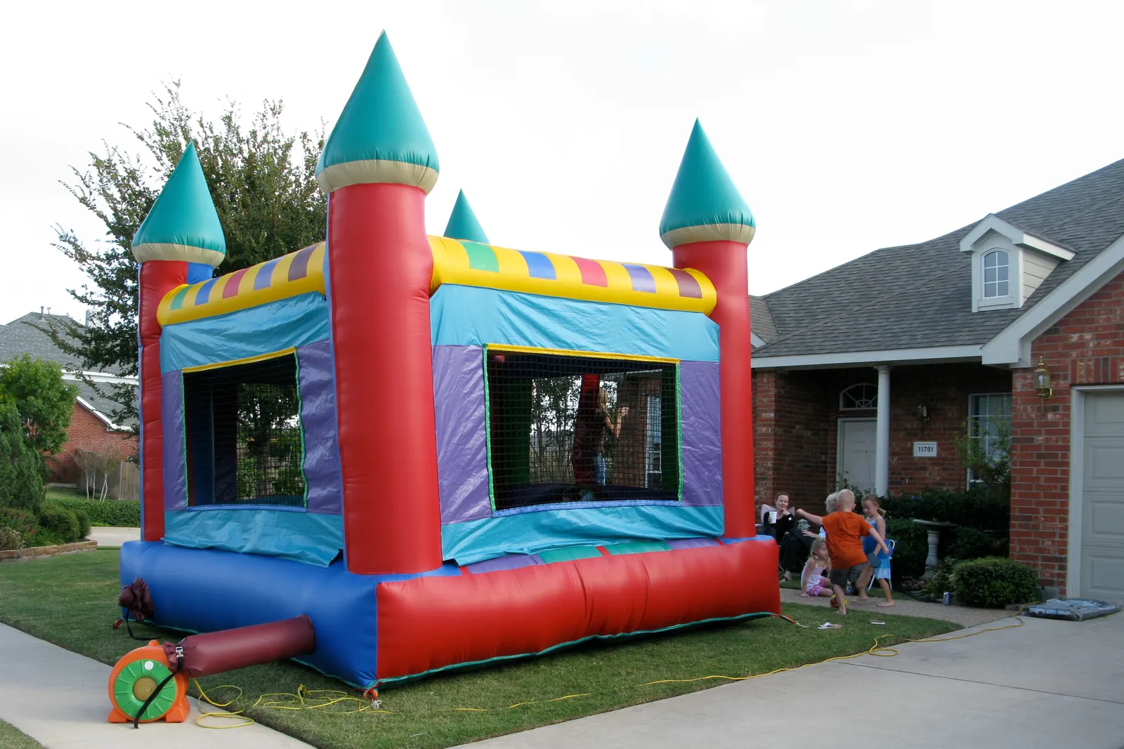 Large colorful jumping castle bounce house rental set up at a backyard birthday party in El Paso TX by Sweet n' Sassy Creations